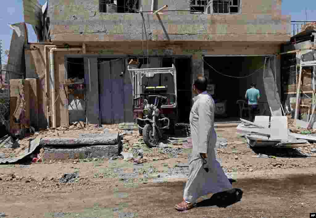 Civilians inspect aftermath of car bomb attack in Husseiniyah area of northeastern Baghdad, Iraq, April 25, 2013.