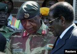FILE - President Robert Mugabe talks to General Constantino Chiwenga in Harare, Zimbabwe.