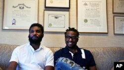 Rashon Nelson, left, and Donte Robinson, right, sit on their attorney's sofa following an interview with The Associated Press in Philadelphia, April 18, 2018.