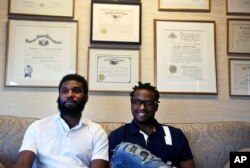 Rashon Nelson, left, and Donte Robinson, right, sit on their attorney's sofa following an interview with The Associated Press in Philadelphia, April 18, 2018.