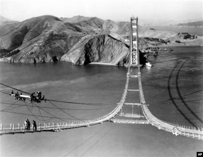 Workers complete the catwalks for the Golden Gate Bridge, spanning the Golden Gate Strait, prior to spinning the bridge cables during construction in San Francisco, California, October 25, 1935. (AP Photo)
