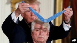 Presiden Donald Trump menganugerahkan penghargaan tertinggi militer AS, Medali Kehormatan, kepada purnawirawan dokter Angkatan Darat Jim McCloughan dalam upacara di Gedung Putih, 31Juli 2017.