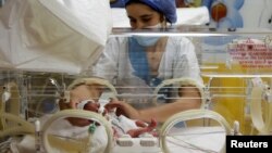 A nurse takes care of one of the nine newborns, lying in an incubator, at the private clinic of Ain Borja in Casablanca, Morocco May 5, 2021. (REUTERS/Youssef Boudlal)