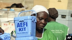 A Nigerian health worker carries vaccination kits at a distribution center ahead of the start of a nation-wide polio immunization campaign, Lagos, February 21, 2011.