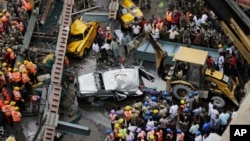 Rescue workers work at the site of a partly collapsed bridge in Kolkata, India, March 31, 2016. 