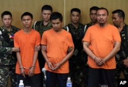 Suspected Muslim extremists, from left in front row, Wendel Apostol Facturan, Musali Mustapha and TJ Tagdaya Macabalang are presented to reporters at Camp Aguinaldo military headquarters in Quezon city, north of Manila, Philippines, Oct. 7, 2016.