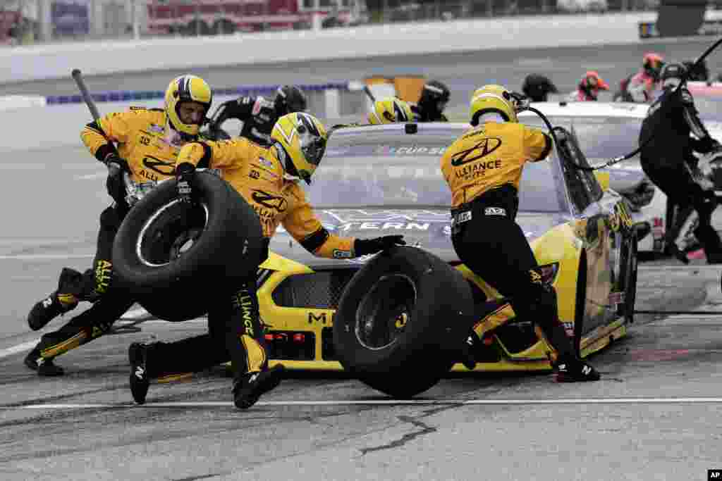 The pit crew hurries as driver Brad Keselowski makes a stop during a NASCAR Cup Series car race, Aug. 2, 2020, at the New Hampshire Motor Speedway in Loudon, New Hampshire.