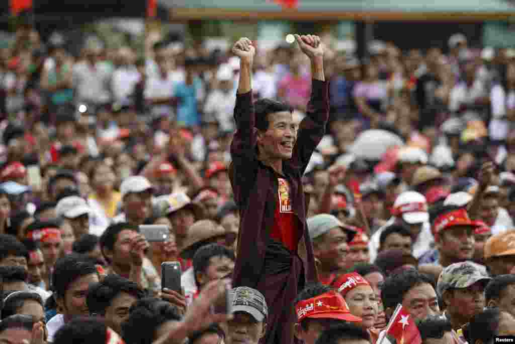 A supporter stands as Myanmar pro-democracy leader Aung San Suu Kyi gives a speech on voter education at the Thanlyin township, outside Yangon.