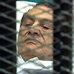 Former Egyptian President Hosni Mubarak is seen through wire mesh in the courtroom for his trial at the Police Academy in Cairo, August third.