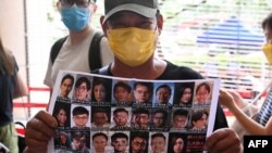 香港民眾手舉47位泛民派活動人士的照片表示支持。（法新社2021年5月31日）