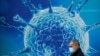 Great Britain, A man wearing a protective face mask walks past an illustration of a virus outside a regional science centre