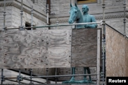 A monument to Confederate General John Hunt Morgan stands encased in a protective scaffolding because of local construction, outside the Old Courthouse in Lexington, Ky., Aug. 15, 2017.