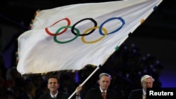 Rio de Janeiro Mayor Eduardo Paes (L) waves the Olympic Flag with IOC President Jacque Rogge (C) and London Mayor Boris Johnson (R) during the closing ceremony of the London 2012 Olympic Games at the Olympic Stadium, August 12, 2012.