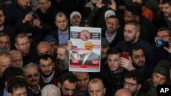 گزشتہ ہفتے استنبول میں جمال خشوگی کی غائبانہ نمازِ جنازہ کے دوران ایک شخص ہاتھ میں مقتول صحافی کا پوسٹر اٹھائے ہوئے ہے۔ (فائل فوٹو)