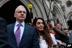 FILE - Wikileaks founder Julian Assange, left, leaves Britain's Royal Courts of Justice after his extradition appeal was heard in central London, July 13, 2011.