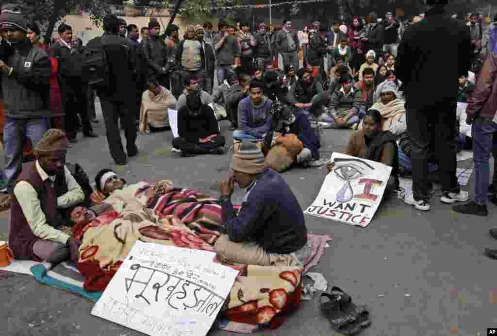 Men lie on a street while on a hunger strike during a protest in New Delhi, India, December 31, 2012. 