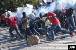 A tear gas canister, fired by the police, hits protesters during the clashes in front of the National Palace, in the center of Haitian capital Port-au-Prince, Feb. 13, 2019, on the sixth day of protests against Haitian President Jovenel Moise.