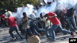 A tear gas canister, fired by the police, hits protesters during the clashes in front of the National Palace, in the center of Haitian capital Port-au-Prince, Feb. 13, 2019, on the sixth day of protests against Haitian President Jovenel Moise.