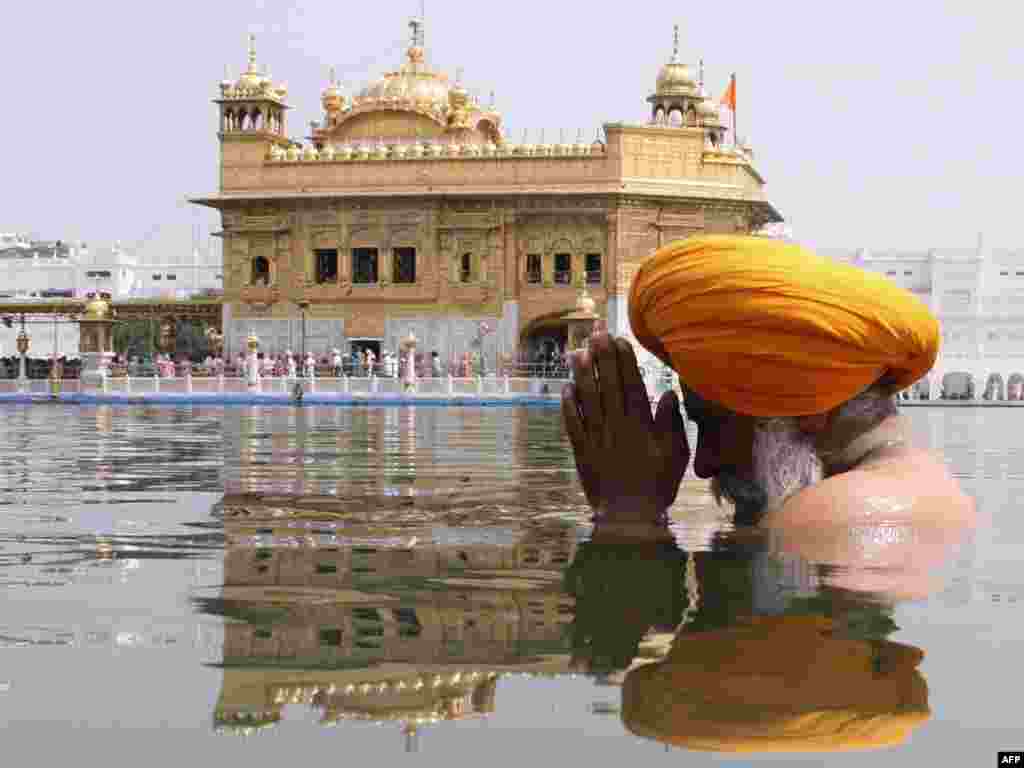 T&iacute;n đồ đạo Sikh ở Ấn Độ ng&acirc;m m&igrave;nh trong nước th&aacute;nh trước Đền V&agrave;ng của th&agrave;nh phố Amritsar.