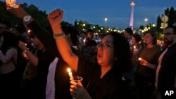 FILE - Activists hold a vigil for a teenage girl who was raped and murdered, in Jakarta, Indonesia, May 4, 2016.