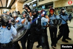 Polisi anti huru-hara Hong Kong membawa semprotan merica dan peralatan lengkap untuk memperketat keamanan di Hong Kong, 25 September 2019.