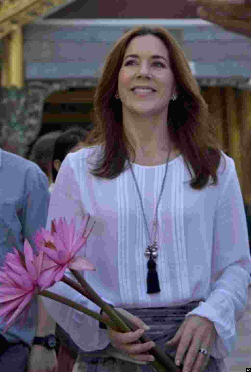 Denmark’s Crown Princess Mary holding flowers visits Shwedagon Pagoda, considered as Myanmar’s holiest Buddhist shrine, in Yangon Saturday, Jan. 11, 2014. Mary, accompanied by Denmark’s Minister for Development Cooperation Rasmus Helveg Petersen, began a