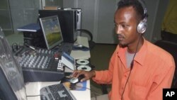 Hassan Yusuf monitors a computer in the control room during a live broadcast of the Somali government run radio. Al-Shabab controls most of southern Somalia uses the Internet and radio stations to get its message out, FILE March 1, 2010.