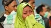 Seorang perempuan menangis melihat kerusakan akibat gempa dan tsunami di Palu, 29 September 2018.