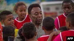 Pemain sepakbolah legendari asal Brazil Pele berbicara dengan anak-anak dalam upacara peresmian teknologi baru lapangan sepakbola yang dipasang di Mineira favela di Rio de Janeiro, Brazil, 10 September 2014. (Foto: dok.) 