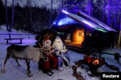 Two men dressed as Santa Claus and Father Frost, Russian equivalent of Santa Claus, stage a performance for visitors at the Royev Ruchey Park in the suburbs of Krasnoyarsk, Russia, December 6, 2017.