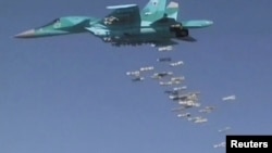 FILE - A still image, taken from video footage and released by Russia's Defense Ministry on Aug. 18, 2016, shows a Russian Sukhoi Su-34 fighter-bomber dropping bombs in the Syrian province of Deir ez-Zor. 