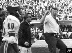 FILE - Oakland Raiders coach John Madden, right, does a sort of jig as he waves his finger and shouts in protest at a referee's call during the third quarter of the team's NFL football game against the Kansas City Chiefs on Dec. 12, 1970, in Oakland, Cali