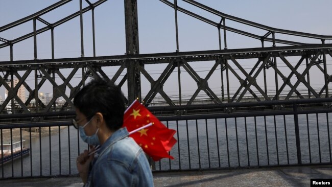 지난 4월 중국 단둥에서 북한 신의주를 연결하는 철교에서 마스크를 쓴 중국인 관광객.