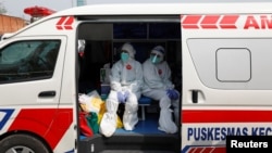 Petugas medis mengenakan pakaian pelindung di dalam ambulans setelah mengumpulkan sampel usap untuk pengetesan virus corona (Covid-19) di pasar tradisional di Jakarta, 2 Juli 2020. (Foto: Reuters)
