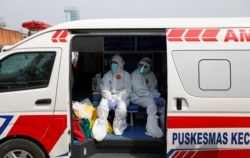 Petugas medis mengenakan pakaian pelindung di dalam ambulans setelah mengumpulkan sampel usap untuk pengetesan virus corona (Covid-19) di pasar tradisional di Jakarta, 2 Juli 2020. (Foto: Reuters)