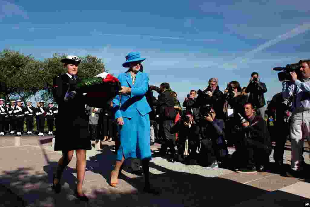 Queen Margrethe of Denmark lays a wreath in front of a war memorial, as part of D-Day commemorations, at Sainte Marie du Mont, France, June 6, 2014.