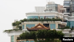 A privately-built illegal temple-like structure is seen on the top of a 20-story residential block in the southern Chinese city of Shenzhen, August 22, 2013. 