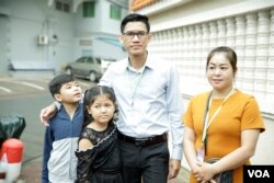 Former Radio Free Asia reporters Yeang Sothearin and his family pose for picture outside Phnom Penh Municipal Court Friday, August 30, 2019. (Tum Malis/VOA Khmer)