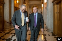 Senate Minority Leader Chuck Schumer, D-N.Y., left, and Sen. Dick Durbin, D-Ill., walk outside the chamber during debate in the Senate on immigration, at the Capitol in Washington, Feb. 14, 2018.