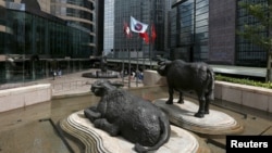 资料照：香港交易广场水牛雕塑前香港证券交易所的旗子在飘扬。（2015年5月28日）