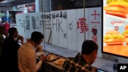 7일 홍콩에서 시민들이 "홍콩에 자유를"이 낙서된 식당에 앉아 식사를 하고 있다. 