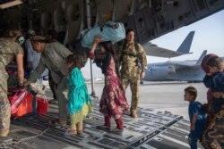In this image provided by the U.S. Air Force, U.S. Air Force loadmasters and pilots assigned to the 816th Expeditionary Airlift Squadron, load people being evacuated from Afghanistan onto a U.S. Air Force C-17 Globemaster III at Kabul's airpoty.