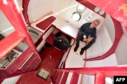 FILE - Jean-Jacques Savin, 71, sits aboard his ship made from a barrel at the shipyard in Ares, southwestern France, Nov. 15, 2018.