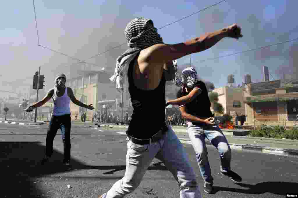 فلسطینی شہری اسرائیلی پولیس پر پتھراؤ کر رہے ہیں۔