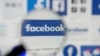 FILE PHOTO: Facebook logos are seen on a screen in this picture illustration