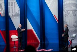 Anderson Cooper (kanan) mendengarkan Presiden Joe Biden saat menjawab pertanyaan dalam siaran langsung yang disiarkan melalui televisi di Pabst Theatre, Milwaukee, Selasa, 16 Februari 2021. (Foto AP / Evan Vucci)