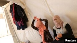 FILE - Yazidi sisters, who escaped from captivity by Islamic State (IS) militants, sit in a tent at Sharya refugee camp on the outskirts of Duhok province, Iraq, July 3, 2015. 