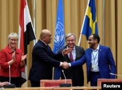 Head of Houthi delegation Mohammed Abdul-Salam (R) and Yemeni Foreign Minister Khaled al-Yaman (2 L) shake hands next to United Nations Secretary General Antonio Guterres and Swedish Foreign Minister Margot Wallstrom (L), during the Yemen peace talks in Sweden, Dec 13, 2018.