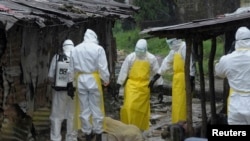Health workers wearing protective clothing prepare to carry an abandoned dead body presenting with Ebola symptoms at Duwala market in Monrovia August 17, 2014. 