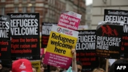 Pro-refugee activists rally with placards outside the French Embassy in central London after an aid convoy headed to northern France was turned back at the port of Dover, June 18, 2016.